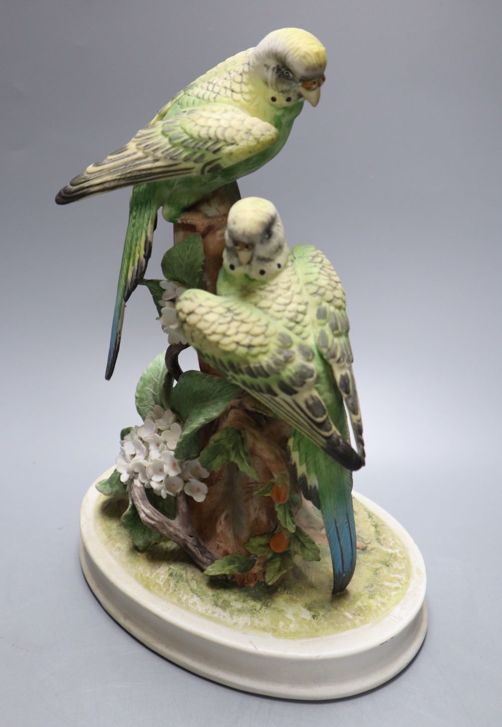 A Continental tinted biscuit porcelain group of two budgerigars, 26cm high